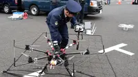 Seorang polisi menyiapkan drone yang dilengkapi jaring saat latihan penanggulangan anti terorisme di Tokyo, Jepang, Minggu (17/1). Latihan yang diikuti 400 petugas kepolisian dan keamanan ini untuk persiapan acara Tokyo maraton. (AFP/Toshifum Kitamura)