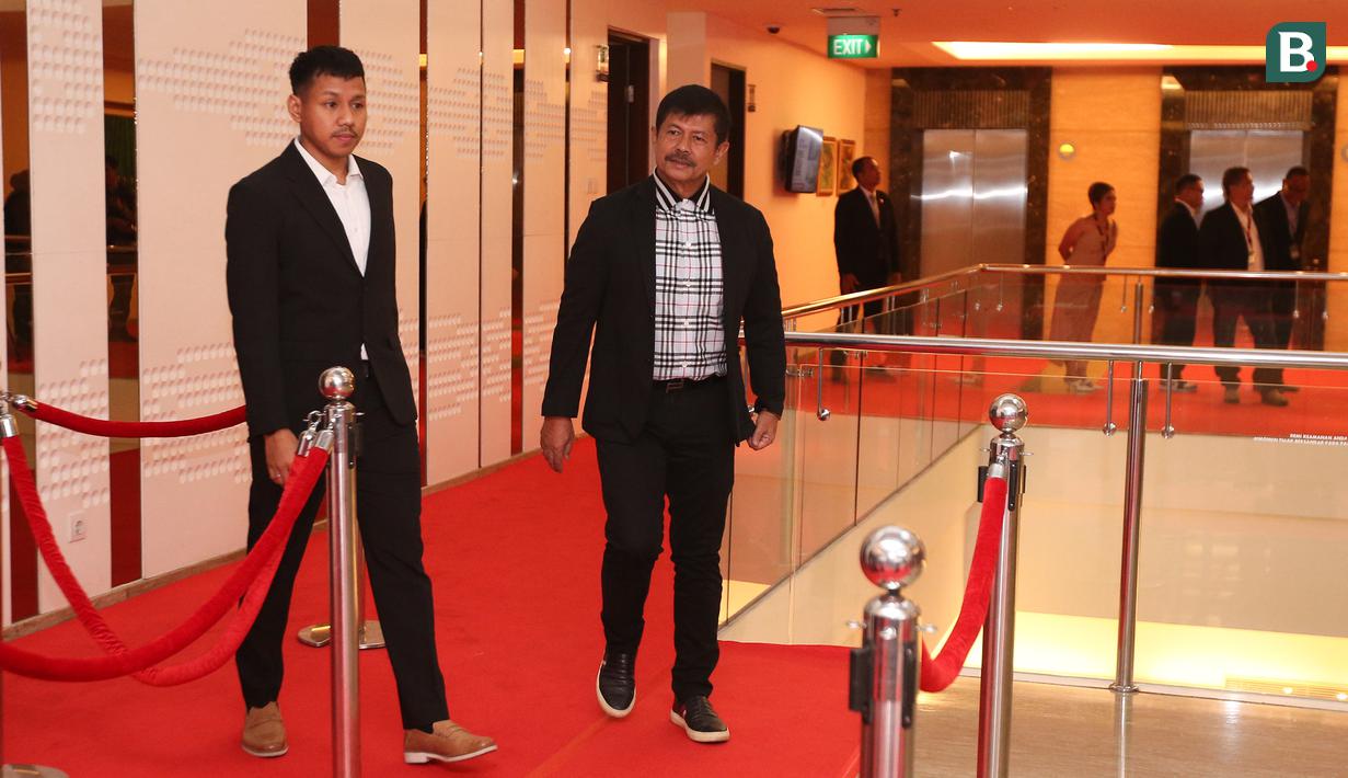 Pelatih kepala Timnas Indonesia U-22, Indra Sjafri berjalan di atas karpet merah pada sebuah acara yang berlangsung di Hotel JS Luwansa, Kuningan, Jakarta, Rabu (19/07/2023). Coach Indra terlihat mengenakan jas hitam dipadukan dengan kemeja kotak-kotak. (Bola.com/Bagaskara Lazuardi)