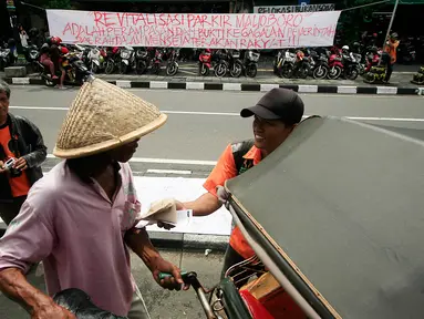 Juru parkir melakukan aksi dengan membagikan nasi bungkus di Jalan Malioboro,Yogyakarta, Jumat (11/3). Dalam aksinya mereka meminta dukungan kepada pengguna jalan yang melintas dan menuntut kejelasan relokasi yang bernurani. (Liputan6.com/Boy Harjanto)