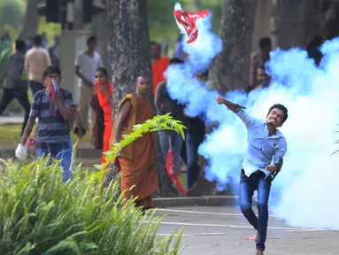 Mahasiswa melempar tabung gas air mata saat unjuk rasa yang berujung bentrok di Kolombo, Sri Lanka, Rabu (17/5). Mereka menolak universitas medis swasta yang dianggap membahayakan tradisi pendidikan yang didanai pemerintah. (AP/Eranga Jayawardena)