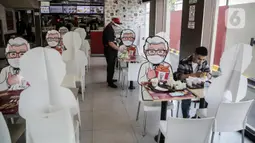 Banner bergambar karakter terlihat di KFC Salemba, Jakarta, Selasa (23/6/2020). Banner bergambar tersebut berguna untuk pembatas bagi pengunjung yang makan di tempat saat fase kenormalan baru. (Liputan6.com/Faizal Fanani)