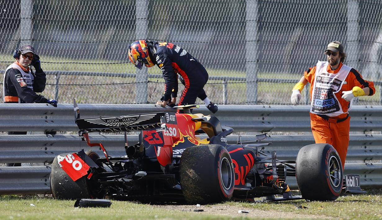 Pembalap Red Bull, Alex Albon, keluar dari mobil usai menabrak pembatas dalam sesi latihan kedua F1 Grand Prix Inggris di sirkuit Silverstone, Inggris, Sabtu (1/8/2020). Albon menempati urutan kedua dengan catatan waktu satu menit 27,364 detik. (AFP/Andrew Boyers/pool)