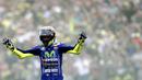 Pebalap Movistar Yamaha, Valentino Rossi, mengangkat tangan saat finish pertama pada MotoGP Belanda di Sirkuit Assen, Assen, Minggu (25/6/2017). Riders asal Italia itu memiliki catatan waktu 41 menit 41,149 detik. (AFP/Vincent Jannink) 