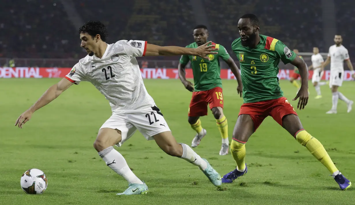 Penyerang Mesir Omar Marmoush mengarahkan bola menjauh dari gelandang Kamerun Moumi Ngamaleu pada laga semifinal Piala Afrika 2021 di Paul Biya Stadium, Jumat (4/2/2022) dini hari WIB. Mesir sukses mengalahkan Kamerun 3-1 via drama adu penalti. (AP Photo/Themba Hadebe)