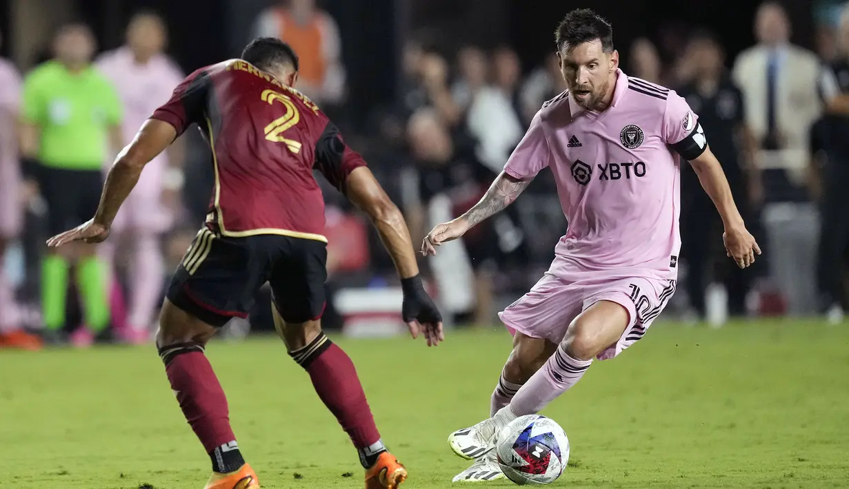 Pemain Inter Miami, Lionel Messi (kanan) berusaha melewati pemain Atlanta United pada laga lanjutan Major League Soccer 2023 di DRV PNK Stadium, Florida, Rabu (26/07/2023) pagi WIB. (AP Photo/Rebecca Blackwell)