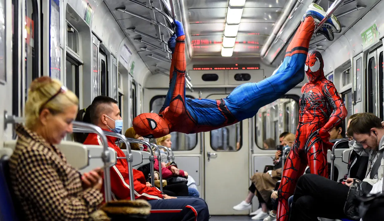 Penari underground yang mengenakan kostum Spiderman tampil di kereta bawah tanah Saint Petersburg, Rusia pada 21 Mei 2021. Penari berkostum Spiderman tersebut tampil berjungkir, melompat dan melakukan gerakan akrobatik di kabin kereta bawah tanah. (Olga MALTSEVA / AFP)