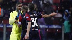 Mike Maignan yang membalasnya dengan meletakkan jari di atas telinganya justru dipersalahkan oleh kapten tim Cagliari, Joao Pedro sehingga keduanya terlibat adu argumen. (La Presse via AP/Alessandro Tocco)