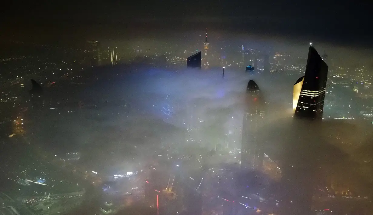 Pemandangan udara memperlihatkan Kuwait City dalam kabut tebal, 22 Januari 2023. Beberapa gedung di Kuwait tercatat sebagai bangunan tertinggi di dunia seperti Al Hamra Tower dan Liberation Tower. (YASSER AL-ZAYYAT/AFP)