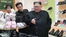 Pemimpin Korea Utara, Kim Jong-Un melihat sepatu saat mengunjungi pabrik sepatu Wonsan, Korea Utara (3/12). (Photo by KCNA VIA KNS / various sources / AFP)