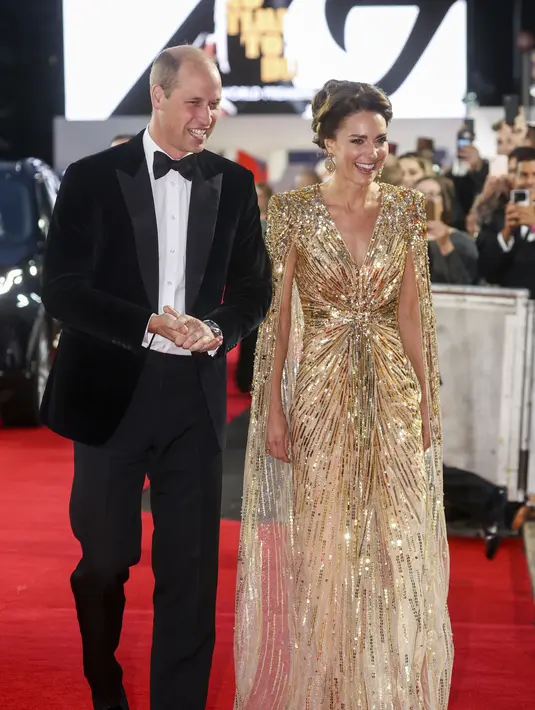 Pangeran William dan Kate Middleton tiba untuk pemutaran perdana premier film James Bond terbaru, No Time To Die, di London, Selasa (28/9/2021). Dress warna gold dengan desain cape dan kerah yang cukup menukik ini membuat pesona Kate Middleton terpancar maksimal. (Chris Jackson/Pool Photo via AP)