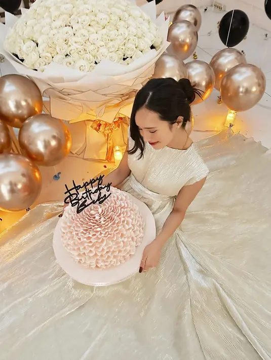 Penampilan Beby pun tak kalah mencuri atensi. Ia tampil begitu menawan bak princess dibalut gaun panjang warna broken white mengilap sambil memegang kue berbentuk bunga yang besar.  [@bebytsabina]