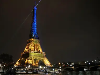 Menara Eiffel diterangi dengan warna bendera Ukraina untuk menandai peringatan satu tahun invasi Rusia ke negara itu di Paris, Prancis, 23 Januari 2023. (AP Photo/Christophe Ena)