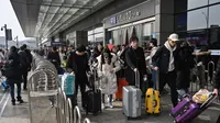 Pemudik tiba di Stasiun Kereta Hongqiao di Shanghai pada Senin (20/1/2020). China berada di tengah-tengah kesibukan migrasi manusia tahunan ketika jutaan orang pulang ke kampung halaman mereka untuk menikmati libur Tahun Baru Imlek bersama keluarga. (HECTOR RETAMAL/AFP)