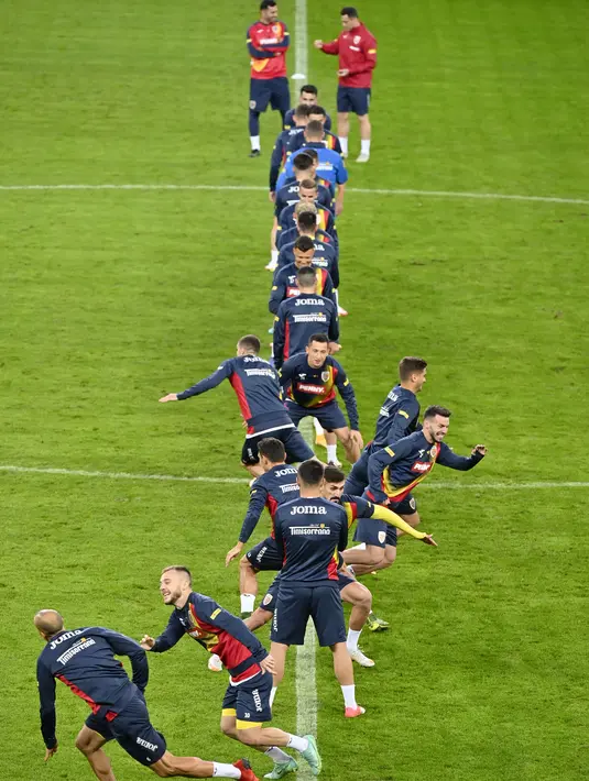 Para pemain timnas Rumania melakukan pemanasan selama sesi latihan di Hamburg, Jerman, Kamis (7/10/2021). Timnas Rumania akan menantang Jerman dalam laga lanjutan Grup J Kualifikasi Piala Dunia 2022 zona Eropa di Volksparkstadion, Sabtu dini hari WIB. (John MACDOUGALL/AFP)