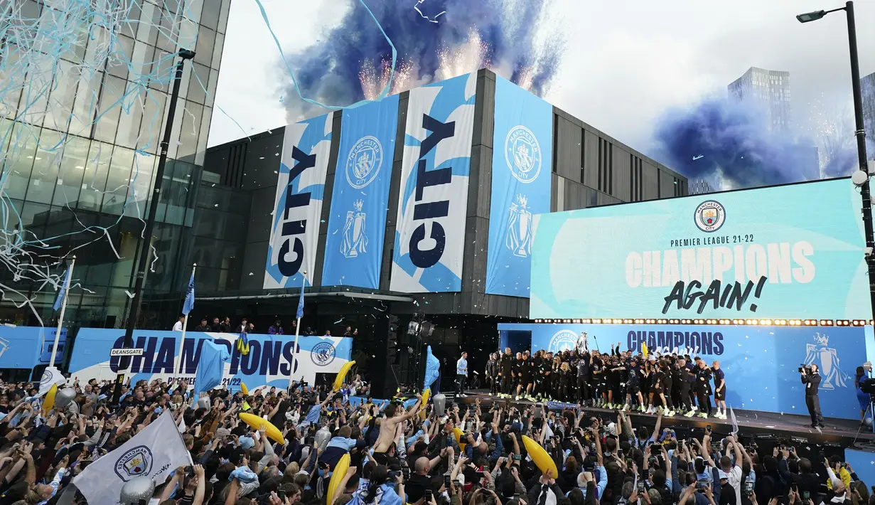 Suar dan pita dilepaskan saat para pemain Manchester City merayakan kemenangan Liga Inggris di atas panggung selama parade kemenangan di Manchester, Inggris, 23 Mei 2022. (AP Photo/Jon Super)