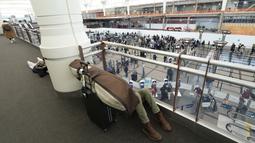 Penumpang tidur di tengah barang bawaannya di atas pos pemeriksaan Bandara Internasional Denver di Denver, AS, Senin (3/1/2022). Badai musim dingin ditambah pandemi membuat frustrasi pelancong yang penerbangan pulang dari liburannya dibatalkan atau ditunda di awal tahun. (AP Photo/David Zalubowski)