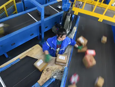 Seorang pekerja ZTO Express menyiapkan paket untuk dipindai dan didistribusikan di kawasan logistik tingkat provinsi di Wilayah Longli, Provinsi Guizhou, China pada 10 November 2020. Perusahaan-perusahaan logistik bersiap menyambut musim belanja "11.11" di China. (Xinhua/Dai Tianfang)