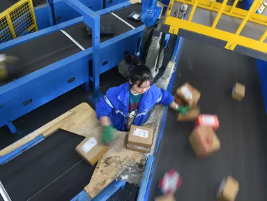Seorang pekerja ZTO Express menyiapkan paket untuk dipindai dan didistribusikan di kawasan logistik tingkat provinsi di Wilayah Longli, Provinsi Guizhou, China pada 10 November 2020. Perusahaan-perusahaan logistik bersiap menyambut musim belanja "11.11" di China. (Xinhua/Dai Tianfang)