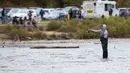 Seorang pria memancing ikan salmon yang tengah bermigrasi ke lokasi bertelur di Sungai Humber di Toronto, Kanada, 18 Oktober 2020. Setiap musim gugur, ribuan ikan salmon di banyak sungai di Ontario berenang menuju ke hulu untuk bertelur, menarik perhatian warga juga para pemancing (Xinhua/Zou Zheng)