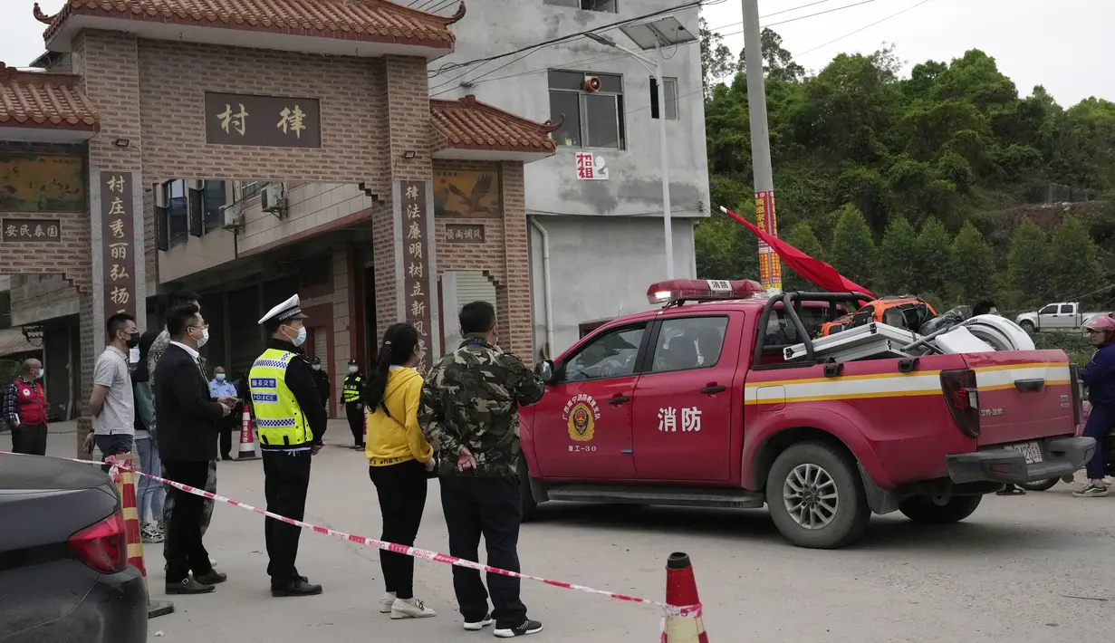 Truk pemadam kebakaran tiba dengan peralatan di pintu masuk desa Lu mengarah ke lokasi jatuhnya pesawat China Eastern di Guangxi, Selasa (23/3/2022). Kecelakaan pesawat dengan 132 orang di dalamnya itu memicu api yang cukup besar dan terlihat pada citra satelit NASA. (AP Photo/Ng Han Guan)