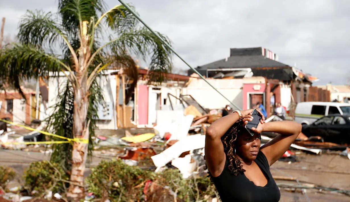 Ekspresi seorang wanita yang berdiri di dekat rumahnya yang rusak akibat hantaman Tornado di New Orleans, AS (7/2). (Sean Gardner/Getty Images/AFP)