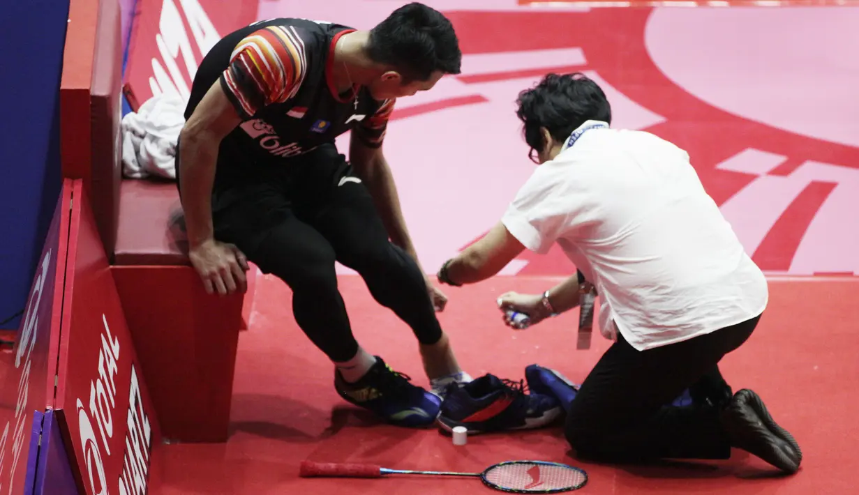 Tunggal putra Indonesia, Jonatan Christie, mendapat perawatan saat melawan Chou Tien Chen pada laga Indonesia Open 2019 di Istora Senayan, Jakarta, Jumat (19/7). Jojo kalah 21-16, 18-21 dan 14-21. (Bola.com/Vitalis Yogi Trisna)