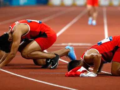 Lalu Muhammad Zohri (tengah) bersama Fadlin, Eko Rimbawan, dan Bayu Kertanegara sujud syukur usai meraih perak dalam final lari 4x100 meter cabang olahraga atletik Asian Games 2018 di Jakarta, Kamis (30/8). (AP Photo/Bernat Armangue)