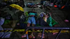 Warga tidur saat antre semalaman untuk tes swab Covid-19 gratis di Wat Phra Sri Mahathat Woramahawihan di Bangkok, Jumat (9/7/2021) dinihari. Thailand pada Kamis (8/7/2021), mencatat rekor 75 kematian Covid-19 dalam 24 jam terakhir, sehingga jumlah kematian menjadi 2.462. (Lillian SUWANRUMPHA/AFP)