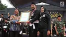 Bupati Ponorogo Ipong Muchlissoni (tengah) menerima Rekor MURI dari Leprid sebagai rekor zikir dan gerakan kolosal pencak silat dengan peserta pendekar terbanyak di Alun-alun Ponorogo, Jawa Timur, Minggu (30/12). (Liputan6.com/HO/Firdaus)