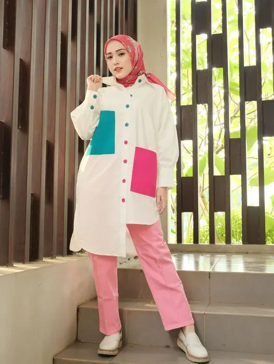 Tampil casual chic dengan kombinasi tunik color block, long pants pink, dan hijab pink bermotif seperti tampilan Adelia Pasha berikut ini. [Instagram/adeliapasha].