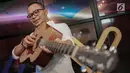 Menteri Ketenagakerjaan M. Hanif Dhakiri berpose dengan gitar sebelum tampil menjadi bintang tamu dalam acara KLY Lounge di Gedung KLY, Gondangdia, Jakarta, Jumat (5/10). (Liputan6.com/Faizal Fanani)