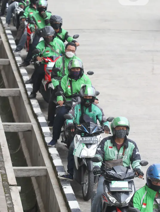 Mitra Gojek antre untuk mengikuti vaksinasi di sentra vaksinasi Indonesia Bangkit Rumah Sakit UI, Depok, Rabu (02/06/2021). Program vaksinasi bagi pelaku transportasi umum diharapkan dapat memberikan rasa aman dan nyaman bagi konsumen. (Liputan6.com/HO/Ading)