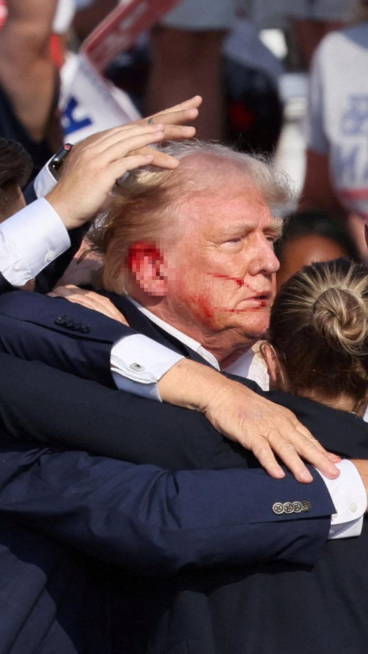 Darah tampak bercucuran di telinga dan wajah Donald Trump akibat insiden penembakan tersebut.&nbsp;Foto: Reuters