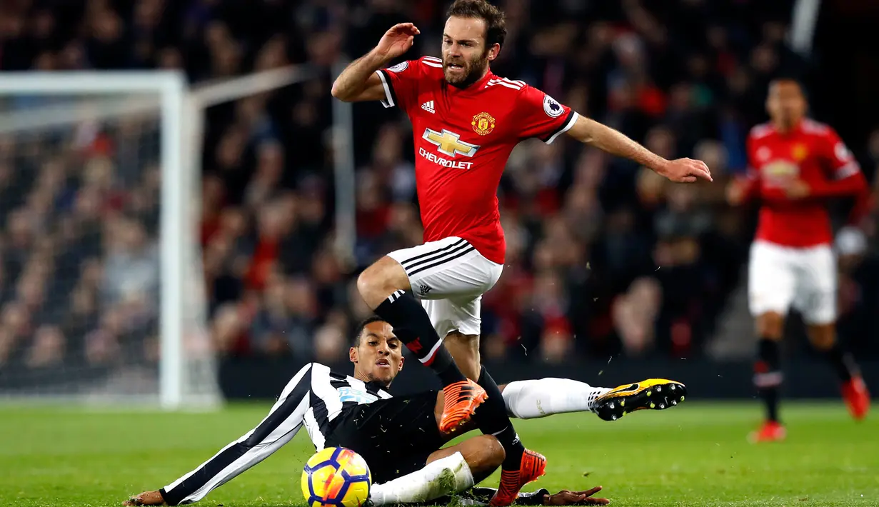 Pemain Manchester United, Juan Mata berebut bola dengan pemain Newcastle United, Isaac Hayden pada laga lanjutan Premier League pekan ke-12 di Old Trafford, Minggu (19/11). MU menang telak 4-1 atas Newcastle. (Martin Rickett/PA via AP)