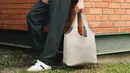 Mile Pakphum juga mengenakan Dior Tote Bag warna beige. Dipadukan jaket coklat dan kaos putih serta celana panjang hitam. [Dior]