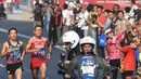Pelari maraton Jepang, Hiroto Inoue bersaing dengan Elhassan Elabbassi dari Bahrain saat memasuki garis finis lomba Asian Games 2018 di jalan Sudirman, Jakarta, Sabtu (25/8). Hiroto menjadi pemenang lari maraton 42 kilometer. (Merdeka.com/Imam Buhori)