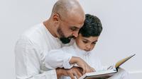 Ilustrasi Islami, muslim, mengaji, membaca Al-Qur'an. (Foto oleh Timur Weber: https://www.pexels.com/id-id/foto/duduk-anak-orang-tua-membaca-9127593/)