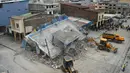 Alat berat dikerahkan di sebuah rumah yang runtuh setelah gempa 7,8 SR mengguncang lepas pantai Pasifik Ekuador di Guayaquil, Minggu (17/4). Gempa kuat tersebut setidaknya menewaskan 246 orang dan melukai 2.527 lainnya.  (REUTERS/Lalo Calle)