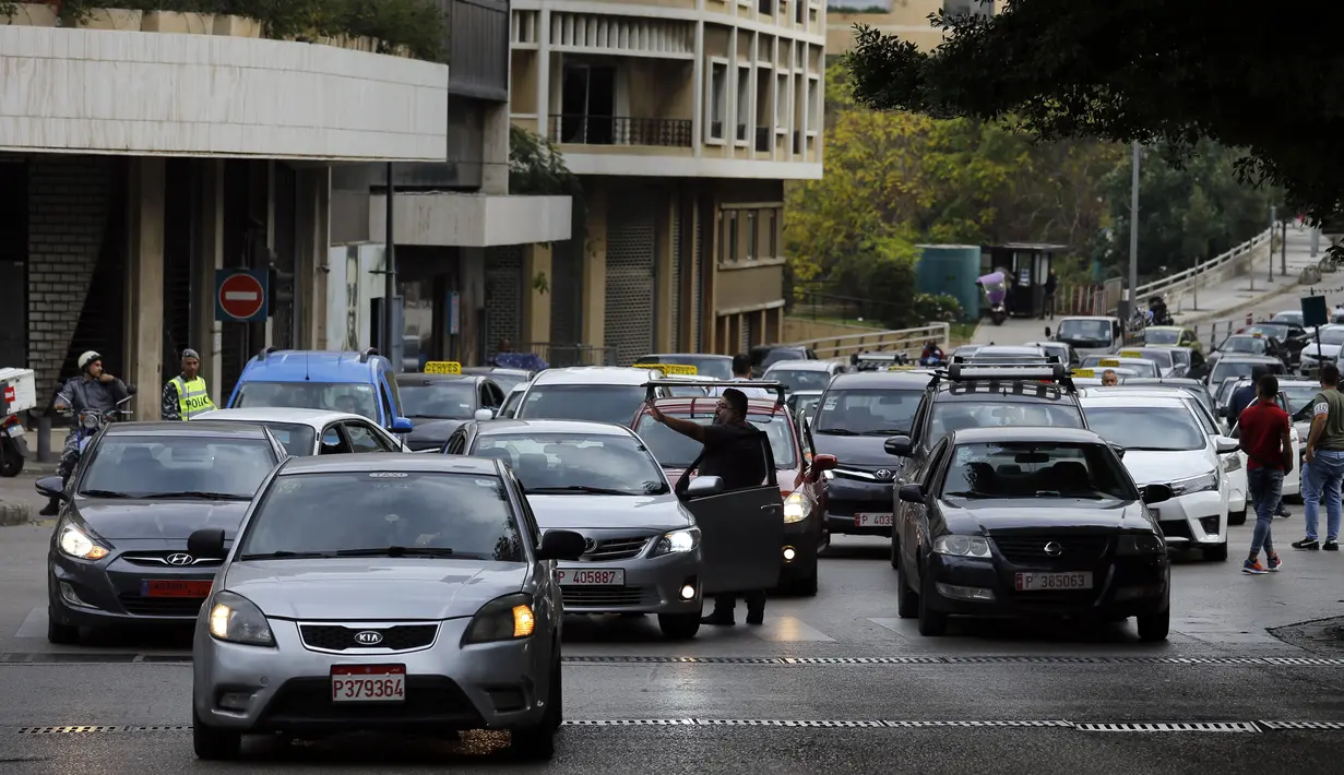 Pengemudi taksi memblokir jalan dengan kendaraan mereka selama aksi protes di Beirut, Lebanon, Selasa (30/11/2021). Mereka memprotes kenaikan harga bensin, barang-barang konsumsi dan jatuhnya mata uang pound Lebanon. (AP Photo/Bilal Hussein)