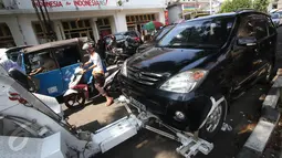Petugas Dishub menderek kendaraan yang parkir liar di kawasan Pasar Baru, Jakarta, Kamis (7/1). Pemprov DKI berencana menaikan denda Rp 3 juta per hari terhadap kendaraan yang terjaring parkir liar. (Liputan6.com/Immanuel Antonius)