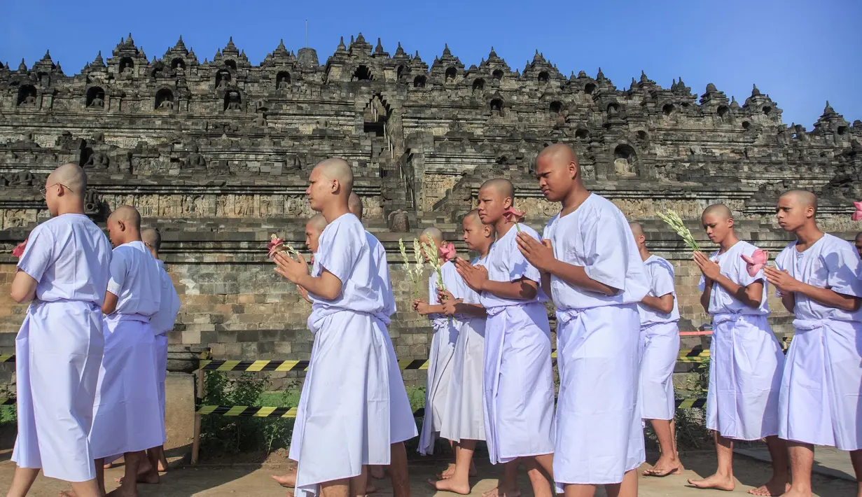 Para calon biksu Buddha bermeditasi dan berjalan tanpa alas kaki mengelilingi candi Borobudur. (DEVI RAHMAN/AFP)