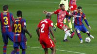 Striker Barcelona, Lionel Messi, melepaskan tendangan saat melawan Granada pada laga Liga Spanyol di Stadion Camp Nou, Jumat (30/4/2021). Barcelona takluk dengan skor 1-2. (AP/Joan Monfort)
