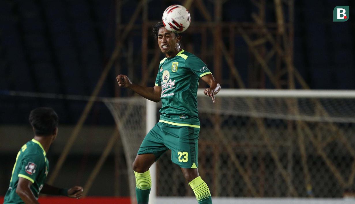 Bek Persebaya Surabaya, Ady Setiawan menghalau bola dengan sundulan saat melawan Persela Lamongan dalam laga Grup C Piala Menpora 2021 di Stadion Si Jalak Harupat, Bandung, Sabtu (3/4/2021). (Bola.com/Ikhwan Yanuar)