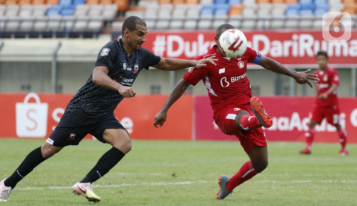 Pemain Persik Kediri Andri Ibo (kanan) menghalau bolasaat dibayangi pemain Madura United Bruno Da Silva Lopes dalam pertandingan babak penyisihan Grup C Piala Menpora 2021 melawan Madura United di Stadion Si Jalak Harupat, Bandung, Sabtu (3/4/2021). (Bola.com/Ikhwan Yanuar)