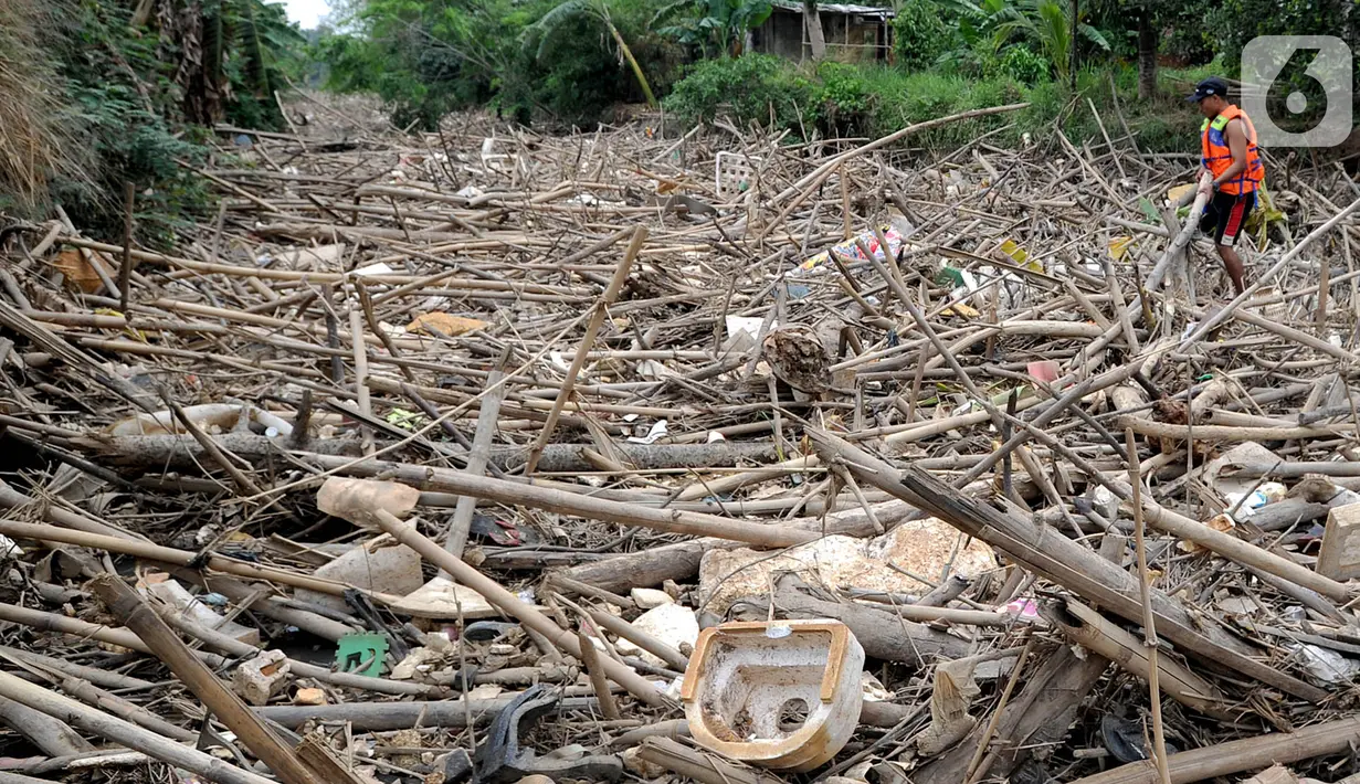 Petugas gabungan membersihkan tumpukan sampah yang menyumbat aliran air Sungai Cikeas di kawasan Bendung Koja Jatiasih, Bekasi, Jawa Barat, Rabu (16/10/2019). Pembersihan sekitar 1.200 meter kubik sampah bambu tersebut diperkirakan menghabiskan waktu dua minggu. (merdeka.com/Arie Basuki)