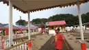 Pekerja melintasi rumah adat betawi jelang pelaksanaan Festival Lebaran Betawi IX di Lapangan Banteng, Jakarta, Kamis (11/8). Festival ini diharapkan dapat menjadi salah satu destinasi wisata di Ibukota. (Liputan6.com/Immanuel Antonius)