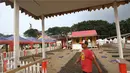 Pekerja melintasi rumah adat betawi jelang pelaksanaan Festival Lebaran Betawi IX di Lapangan Banteng, Jakarta, Kamis (11/8). Festival ini diharapkan dapat menjadi salah satu destinasi wisata di Ibukota. (Liputan6.com/Immanuel Antonius)