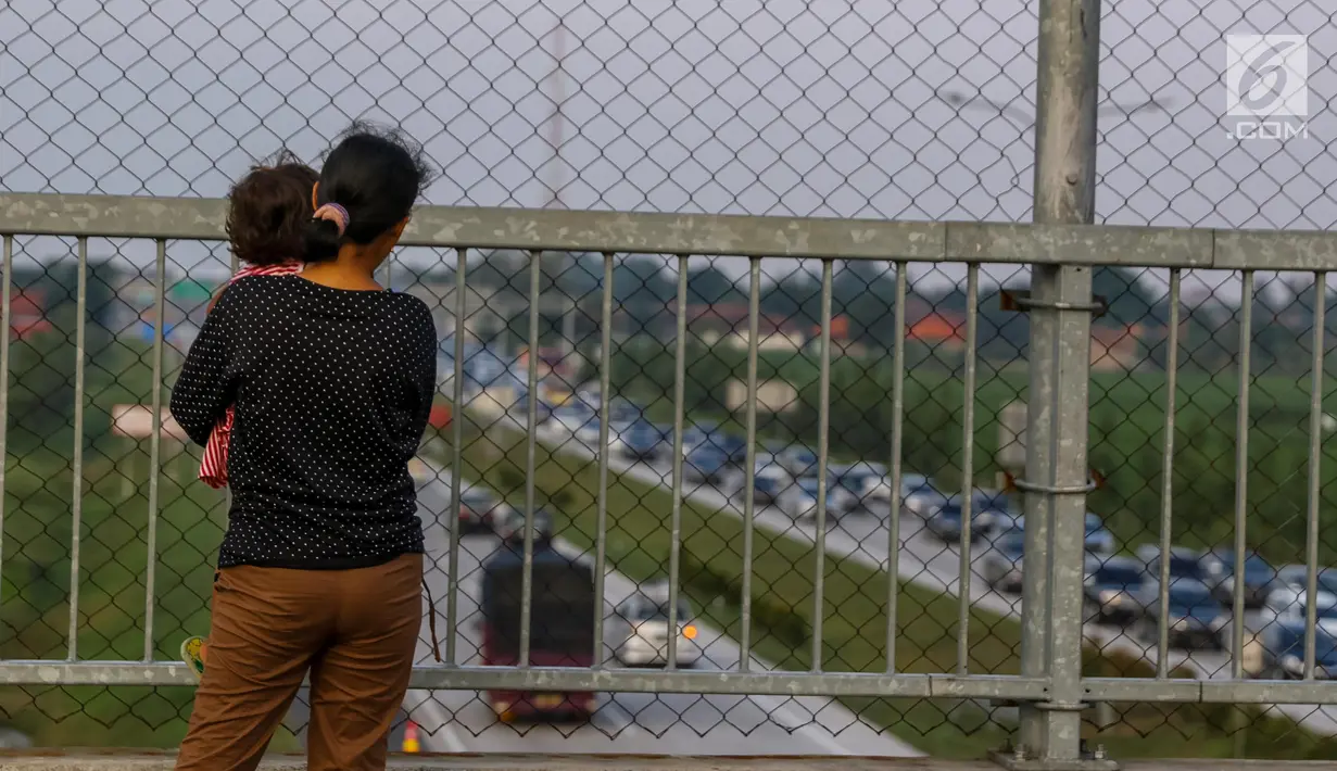 Warga melihat kemacetan arus lalu lintas di Gerbang Tol Utama Palimanan, Cirebon, Jawa Barat, Kamis (29/6). Menjelang sore hari warga berwisata sambil menyaksikan kemacetan volume kendaraan saat arus balik menuju Jakarta. (Liputan6.com/Faizal Fanani)