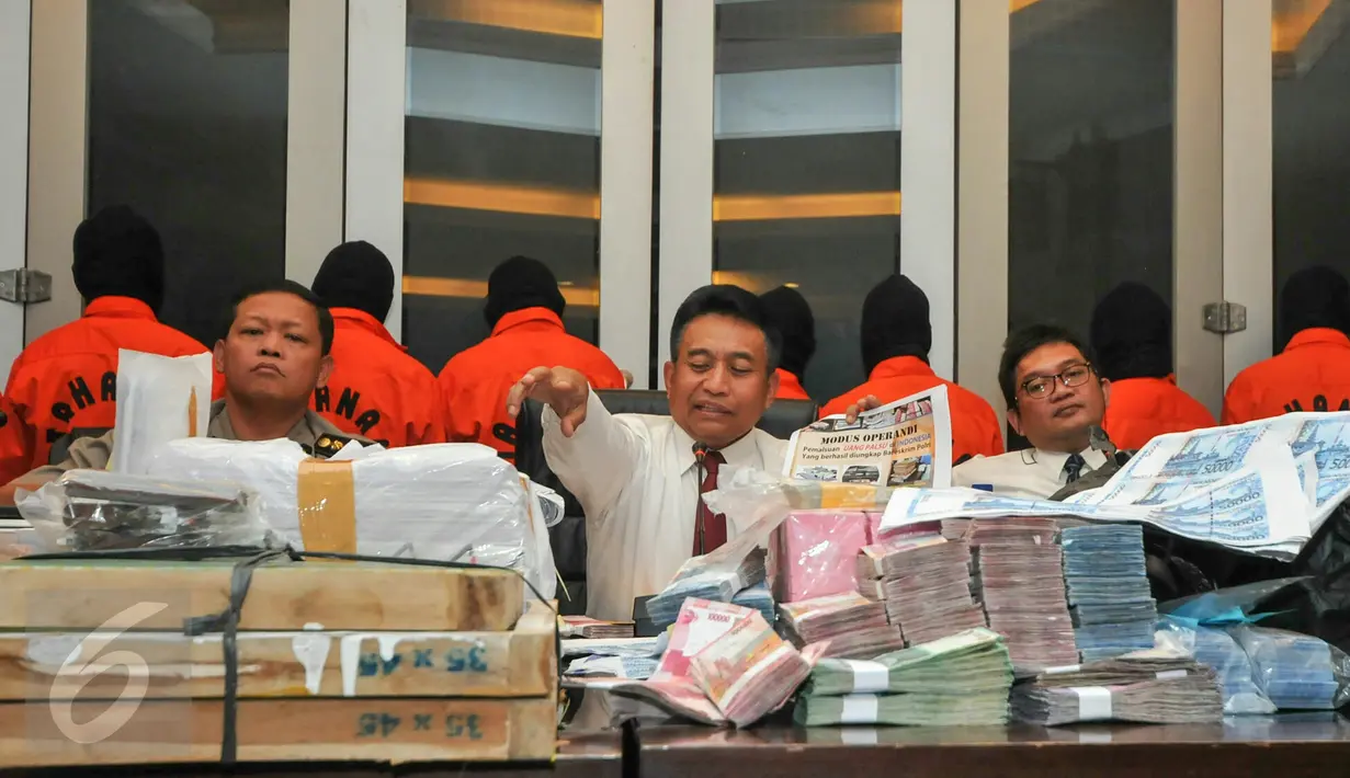 Ratusan lembar uang palsu yang berhasil diamankan Bareskrim Polri, Jakarta, Senin (7/12/2015). Selain ratusan lembar uang palsu pecahan Rp100.000 dan 50.000, petugas juga mengamankan alat print pembuat uang palsu. (Liputan6.com/Yoppy Renato)