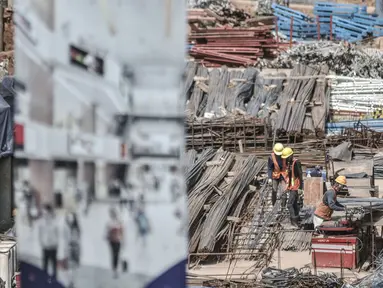 Aktivitas pekerja saat menyelesaikan proyek pembangunan Pasar Senen Blok I dan II, Jakarta, Minggu (15/11/2020). Pembangunan gedung pasar yang berada di lahan seluas 69.600 meter persegi itu terus dikebut setelah sebelumnya ludes akibat kebakaran pada 2017. (merdeka.com/Iqbal S Nugroho)